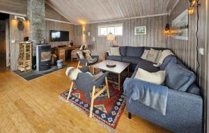 uma sala de estar com um sofá azul e cadeiras em Stunning Home In Fl With Wifi em Eggedal
