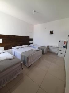 um quarto com três camas e uma secretária em Central Palace Hotel em Fortaleza