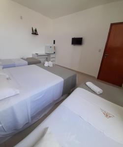 um quarto com duas camas e uma televisão na parede em Central Palace Hotel em Fortaleza