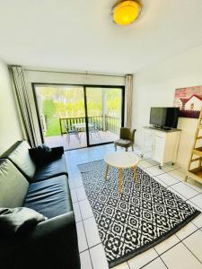 a living room with a couch and a table at Duplex T3 2 étoiles bord de lac 65mcarrés in Biscarrosse