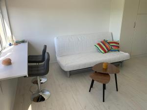 ein Wohnzimmer mit einem weißen Sofa und einem Tisch in der Unterkunft Gwiezdna łąka 