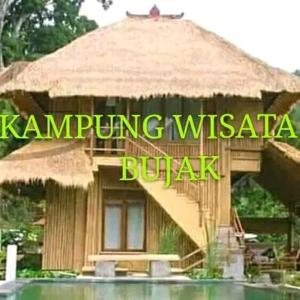 MantangにあるArea bebasのわらぶき屋根の小屋とプールのある小さな建物