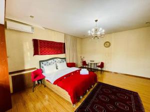 - une chambre avec un grand lit et une table dans l'établissement M.O.O.N. Apartments - Ташкент -Айбек Центр, à Yakkasaray