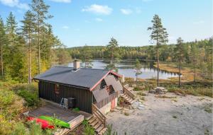 a small house with a deck next to a lake at Stunning Home In Setskog With Lake View 