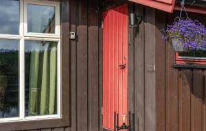 a building with a red door and a window with a flower pot at Stunning Home In Setskog With Lake View 