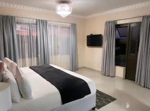 1 dormitorio con 1 cama blanca grande y ventanas en Dineo's Lodge and Spa, en Burgersfort