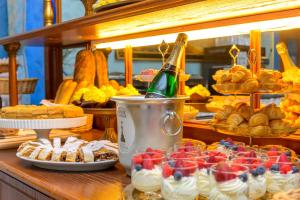 a buffet with desserts and a bottle of champagne at Hotel Kinsky Fountain in Prague
