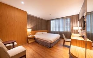 Pokój hotelowy z łóżkiem i biurkiem w obiekcie 雲富大飯店 Hotel Cloud-ZhongShan w Tajpej