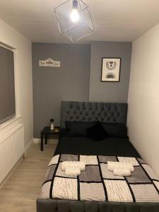 a bedroom with a bed with a black and white blanket at Cosy Home In Nottingham Near QMC and University Free Parking! in Nottingham