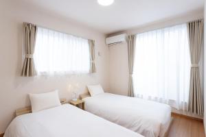 two beds in a room with a window at Gen-an no Sato - 幻庵の里 in Odawara