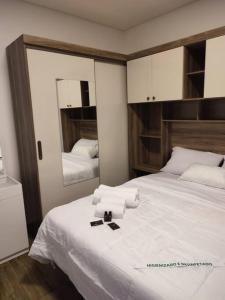 a bedroom with a bed with towels and a mirror at Residencial Luce Del Sole - Casa Nº 6 in Joinville