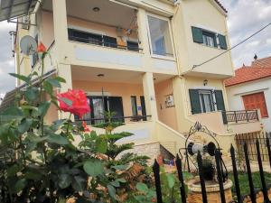 a house with a red rose in front of it at Studio Apartments Eirini in Pyrgi Thermis