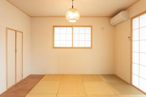 an empty room with a window and wooden floors at Gen-an no Sato - 幻庵の里 in Odawara