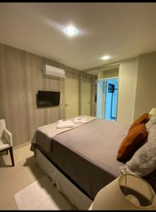 una camera con un grande letto e uno specchio di PAJUCARA FRONT BEACH 2 a Maceió