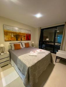 a bedroom with a bed and a large window at PAJUCARA FRONT BEACH 2 in Maceió