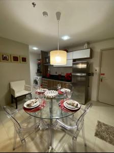 una cocina con una mesa de cristal con platos. en PAJUCARA FRONT BEACH 2 en Maceió