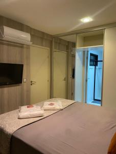 a bedroom with a bed with a mirror and a television at PAJUCARA FRONT BEACH 2 in Maceió