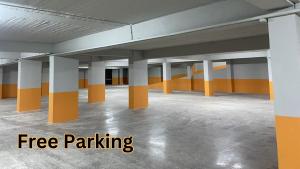 un parking vide avec des colonnes orange et blanche dans l'établissement Blumont Aparthotel Durres, à Durrës