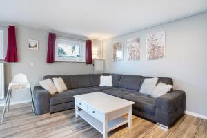 un salon avec un canapé et une table dans l'établissement Rügenferienhaus komplett, à Schaprode