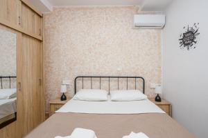 um quarto com uma cama e duas mesas com candeeiros em Sunrise Apartment em Heraclião