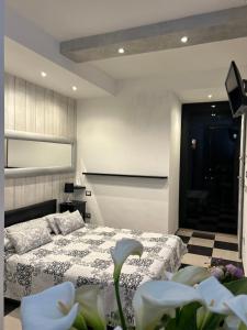 a bedroom with a bed and a television and flowers at Affittacamere 4 bassotti in Monterosso al Mare