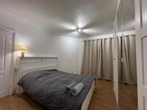Elegant living, 3 bedroom modern house في لندن: غرفة نوم عليها سرير وفوط