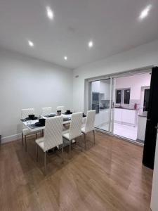 Elegant living, 3 bedroom modern house في لندن: غرفة طعام مع طاولة وكراسي بيضاء