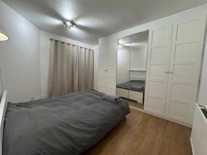 Elegant living, 3 bedroom modern house في لندن: غرفة نوم بسرير وخزانة
