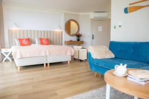ein Schlafzimmer mit einem Bett und einem blauen Sofa in der Unterkunft Szerokie Wody Sea & Sand Ustka in Ustka