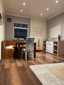 a living room with a table and a kitchen with a guitar at Flat for up to 4 people in Dresden-Striesen in Dresden