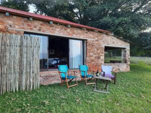 a group of chairs and a table in front of a building at Kwaggaskop Farm Kliphuis in Dullstroom +26 photos