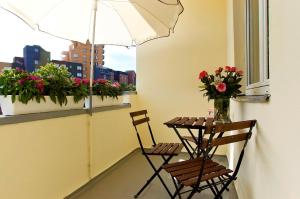 uma mesa e duas cadeiras numa varanda com flores em Central City West 3 em Berlim