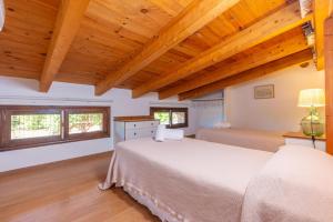 a bedroom with a large bed and two windows at Can Rosillo in Llucmajor