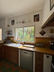 uma cozinha com um lavatório e uma janela em La Boissetane, maison provençale avec piscine et jardin, au pied du Luberon em Saint-Martin-de-Castillon
