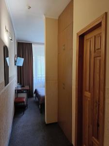 a hotel room with a bedroom with a bed and a door at Girska Tysa Health Resort in Kvasy