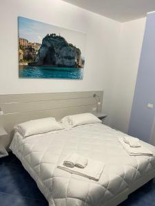 a bedroom with a bed with a painting on the wall at Hotel La Giara in Zambrone