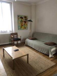 een woonkamer met een bed en een salontafel bij Jolie maison hyper centre de Châteauroux in Châteauroux
