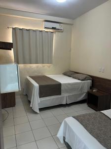 ein Hotelzimmer mit 2 Betten und einem Fenster in der Unterkunft San Felipe Hotel in Colinas do Tocantins