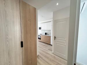 a hallway with a white door and a kitchen at Rebeca - 4 pers Standing - Hyper centre -Terrasse in Saint-Raphaël