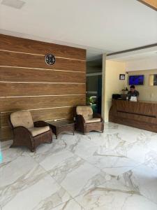 eine Lobby mit zwei Stühlen und einer Uhr an der Wand in der Unterkunft San Felipe Hotel in Colinas do Tocantins