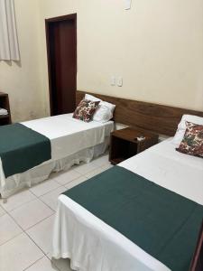 2 Betten nebeneinander in einem Zimmer in der Unterkunft San Felipe Hotel in Colinas do Tocantins