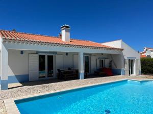 a villa with a swimming pool in front of a house at Villa Alba in Aljezur
