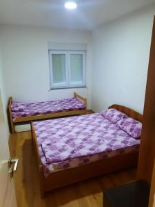 トレビニェにあるK&M Apartmanの紫のシーツが備わる客室内のベッド2台 +8枚の写真