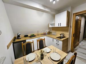 a kitchen with a dining table and a kitchen with white cabinets at Family Rooms in Zabrze +31 photos