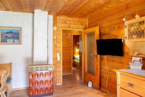 a living room with a television in a log cabin at Grashäusl in Grainau