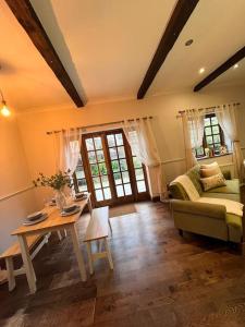 - un salon avec un canapé et une table dans l'établissement Rare & exclusive country cottage, à Hurn