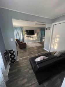 a living room with a black couch and a television at Beautiful Trailside Haven on the Edge of Town in Hibbing