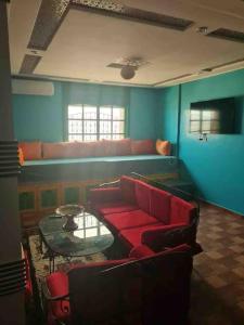 Tamraght Ou FellaTamraght 2 Bedroom Apt with Oceanview 3. Level的客厅配有红色的沙发和桌子
