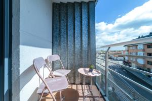 2 sillas blancas y una mesa en el balcón en Ca Mari Apartamento con garaje en Zamora