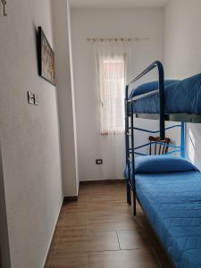 a bedroom with two bunk beds and a window at CASA FLORIS in Tertenìa
